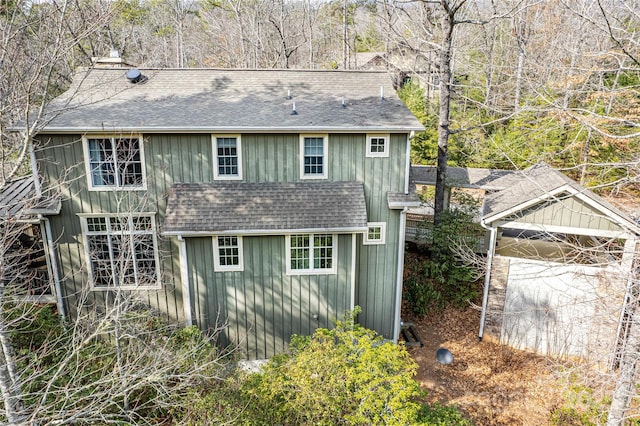 rear view of house featuring roof with shingles