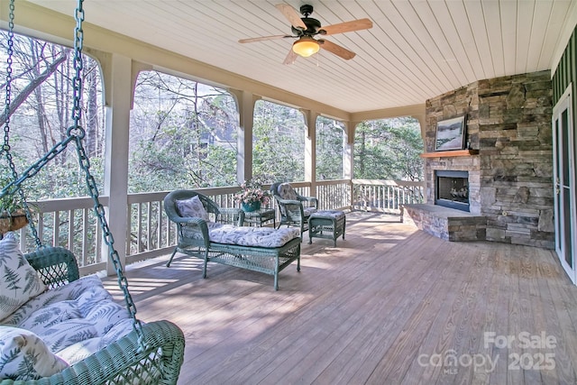 wooden deck with an outdoor living space with a fireplace and a ceiling fan