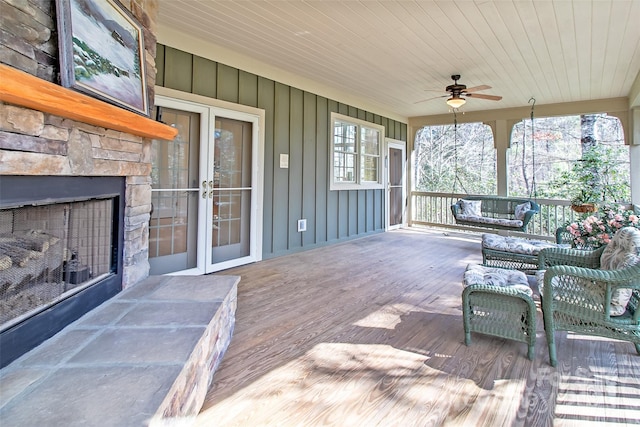 wooden deck with a fireplace and ceiling fan