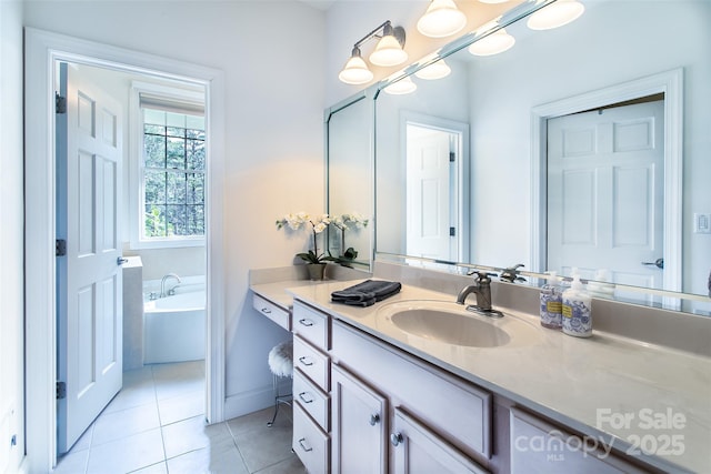 full bath with vanity, baseboards, a bath, and tile patterned floors