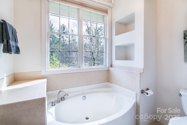 full bathroom featuring toilet and a garden tub