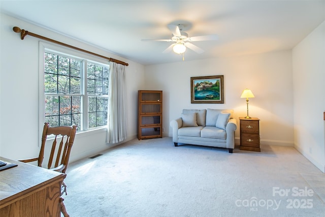 office area featuring baseboards, visible vents, light carpet, and a ceiling fan