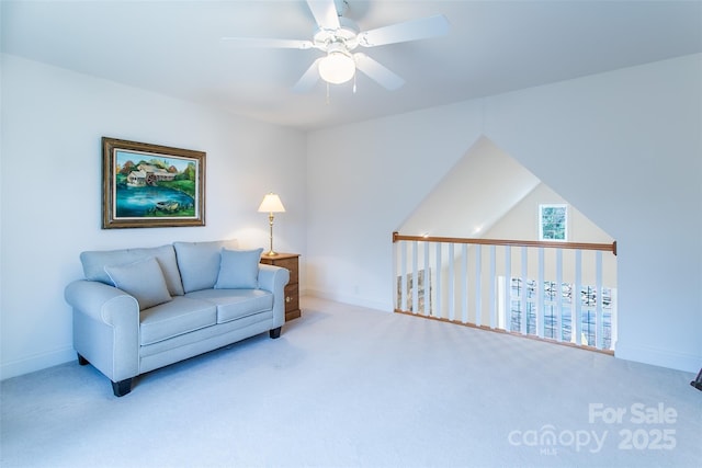 carpeted living area featuring baseboards and a ceiling fan