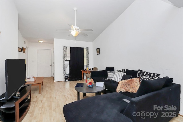 living room featuring ceiling fan, lofted ceiling, and light wood-type flooring