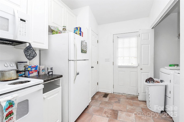 kitchen with white cabinetry, white appliances, and washing machine and clothes dryer