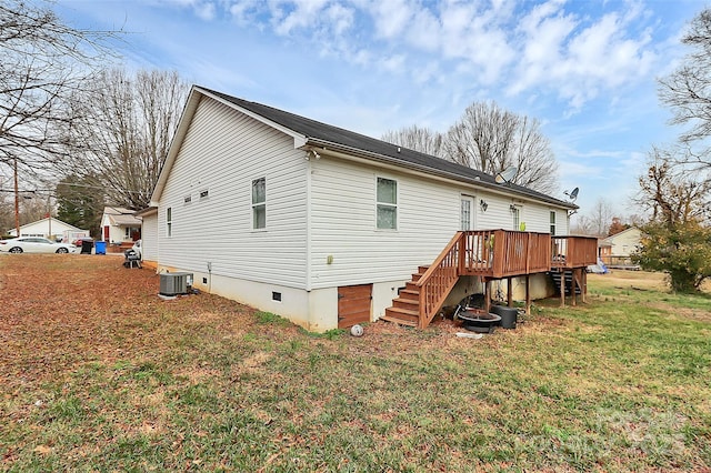 back of property featuring a wooden deck, central AC unit, and a lawn