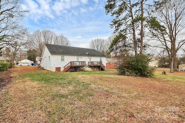 rear view of house with a wooden deck and a lawn