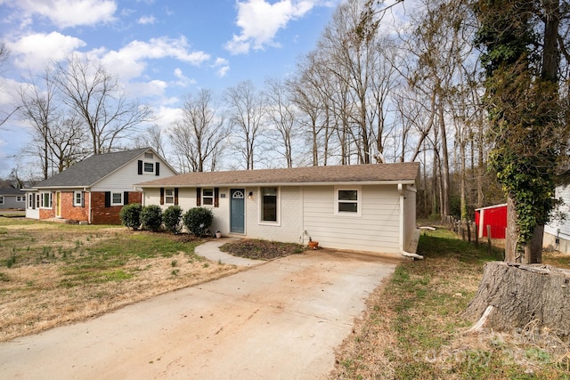 view of front of property with concrete driveway, brick siding, and a front yard