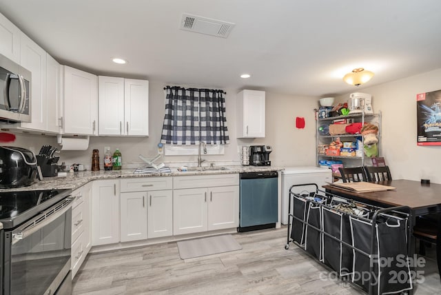 kitchen with visible vents, stainless steel microwave, a sink, range with electric cooktop, and dishwashing machine