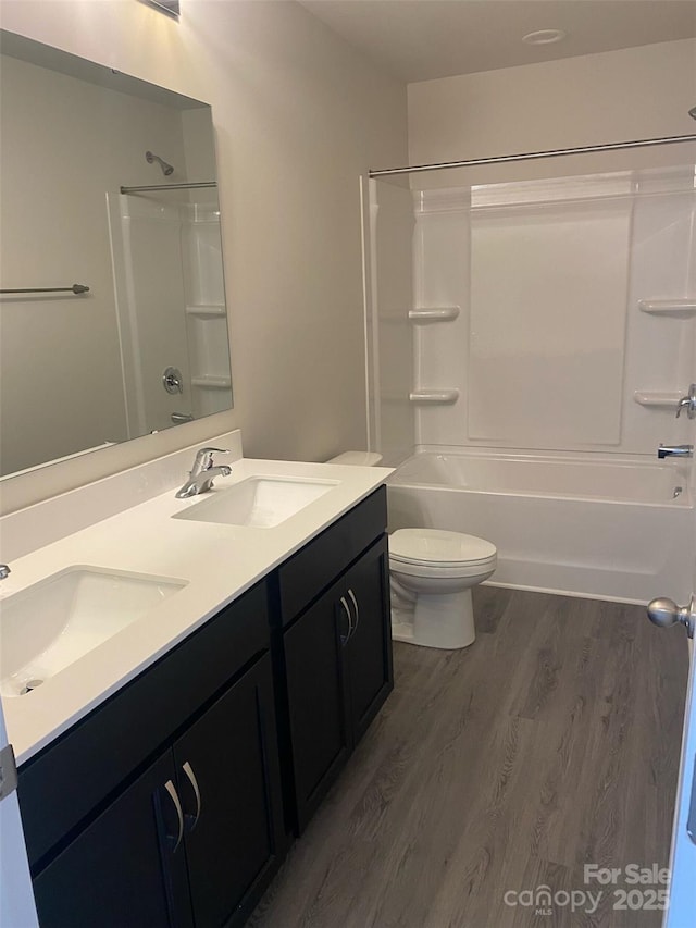 full bathroom with shower / bathing tub combination, vanity, hardwood / wood-style flooring, and toilet