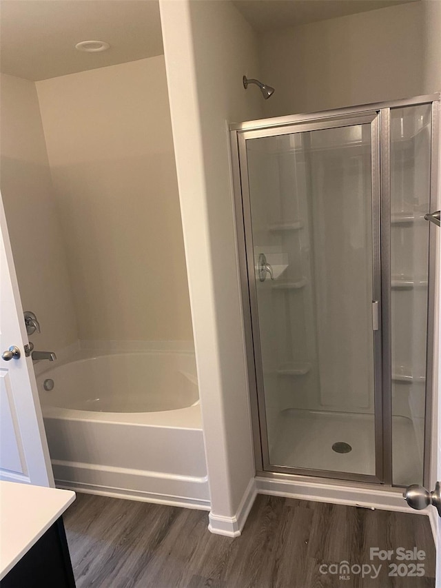 bathroom featuring hardwood / wood-style floors and independent shower and bath