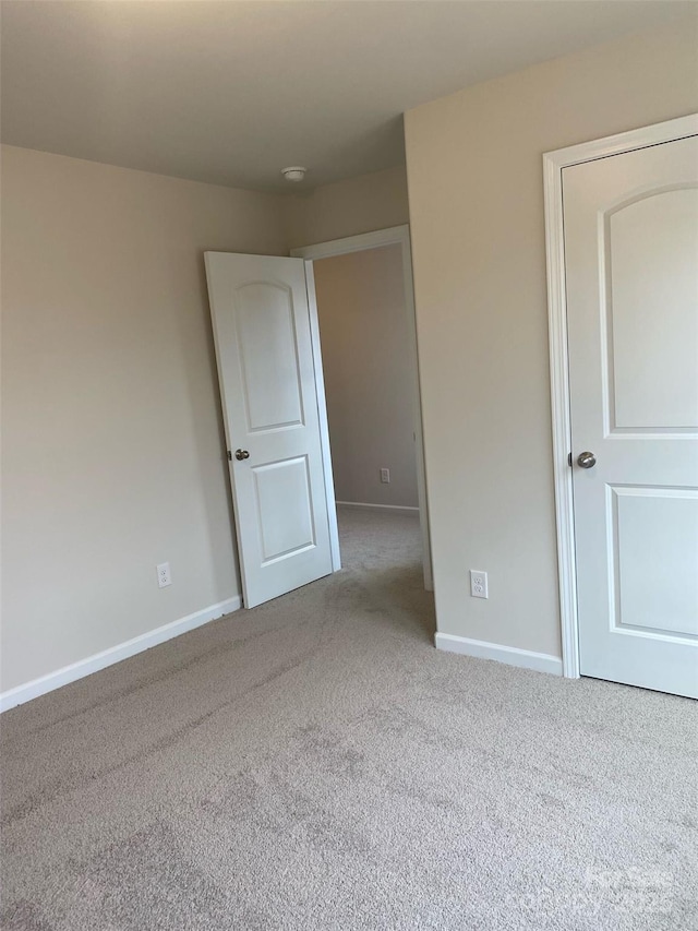 unfurnished room featuring light colored carpet