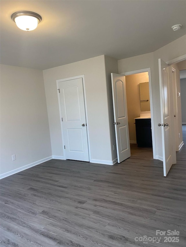 unfurnished bedroom with dark wood-type flooring