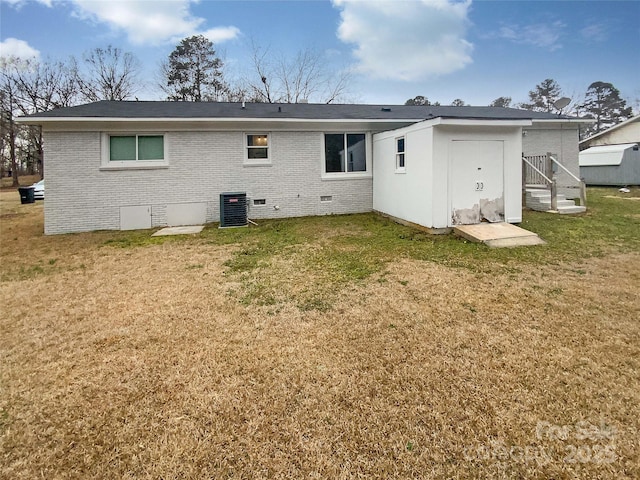 rear view of house featuring a lawn and central air condition unit