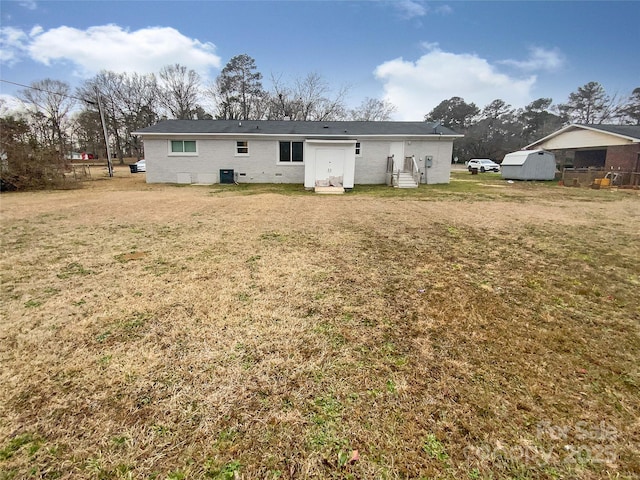 back of property featuring a yard and central air condition unit