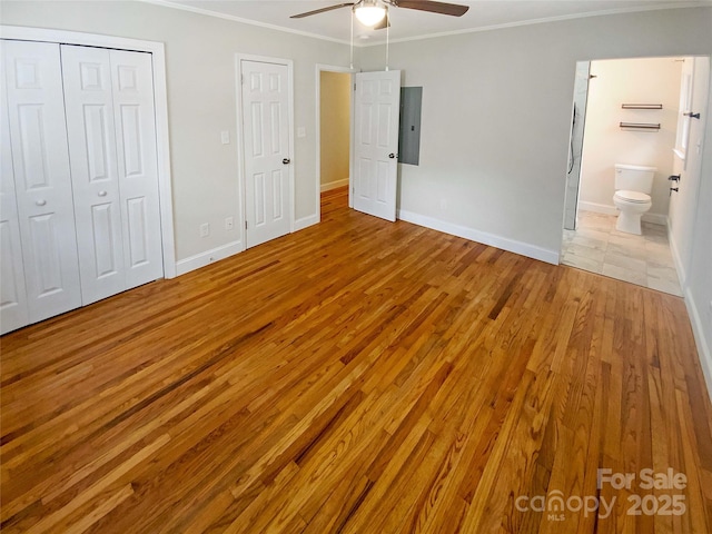 unfurnished bedroom with crown molding, connected bathroom, ceiling fan, and light hardwood / wood-style floors