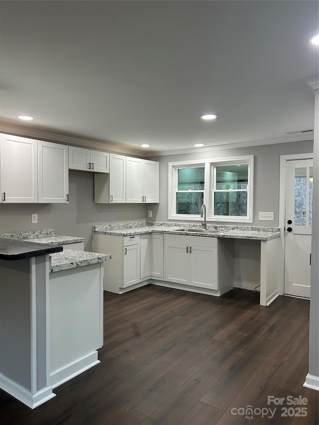 kitchen featuring dark wood finished floors, a sink, white cabinetry, and recessed lighting