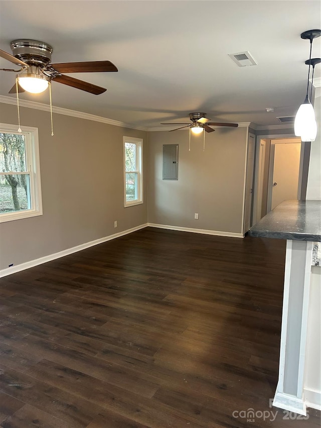 empty room with dark wood finished floors, visible vents, ornamental molding, electric panel, and baseboards