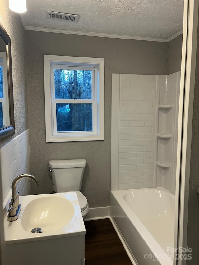 full bath featuring visible vents, toilet, wood finished floors, a textured ceiling, and vanity