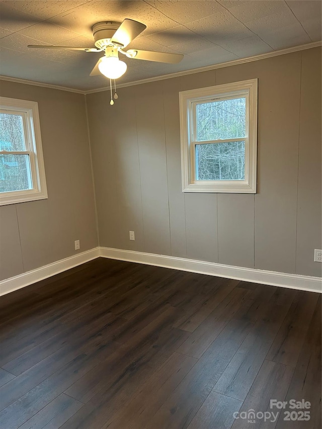 unfurnished room featuring baseboards, dark wood-type flooring, a ceiling fan, and crown molding