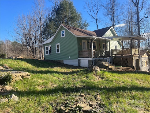 view of side of property with covered porch and a yard