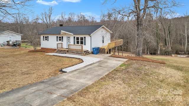 view of front of house featuring a wooden deck and a front lawn