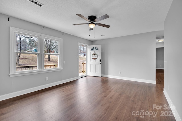 spare room featuring ceiling fan, dark hardwood / wood-style floors, and a textured ceiling