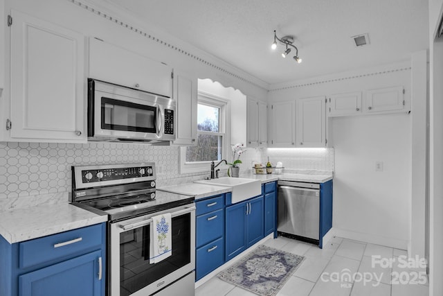 kitchen with blue cabinetry, sink, appliances with stainless steel finishes, white cabinets, and backsplash