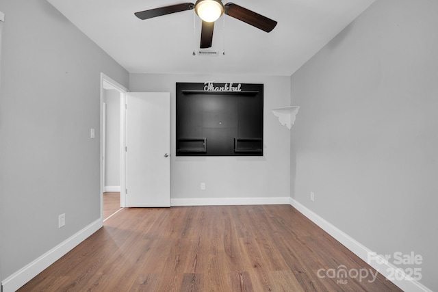 unfurnished living room featuring hardwood / wood-style floors and ceiling fan