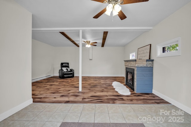 workout area with baseboard heating, ceiling fan, a brick fireplace, and light tile patterned floors