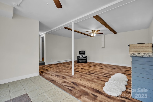 basement with a baseboard heating unit, hardwood / wood-style floors, and ceiling fan