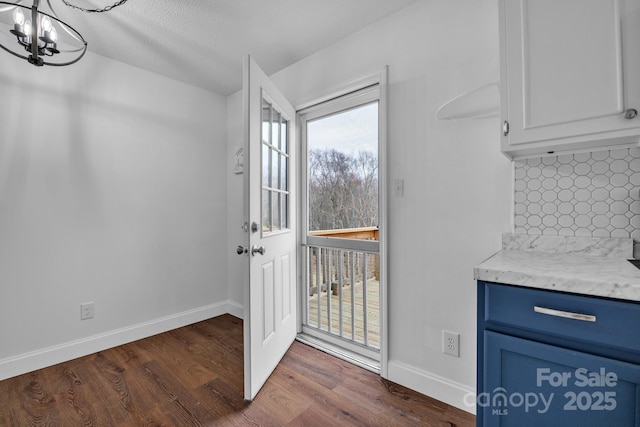 entryway featuring an inviting chandelier and dark hardwood / wood-style floors