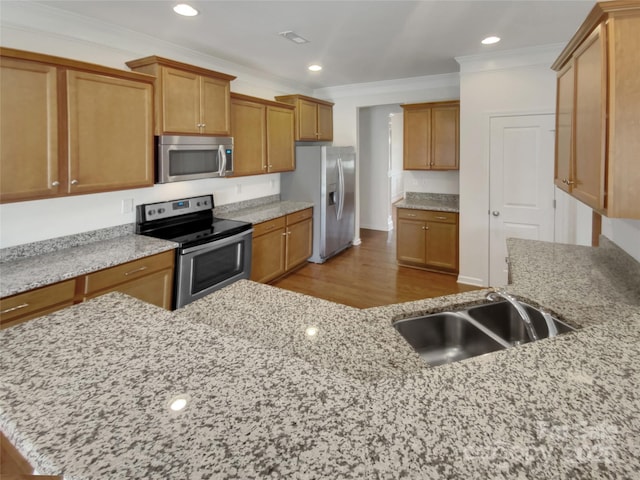 kitchen with light stone counters, crown molding, light hardwood / wood-style flooring, and stainless steel appliances