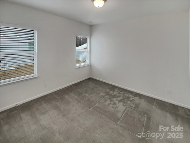 spare room with dark colored carpet