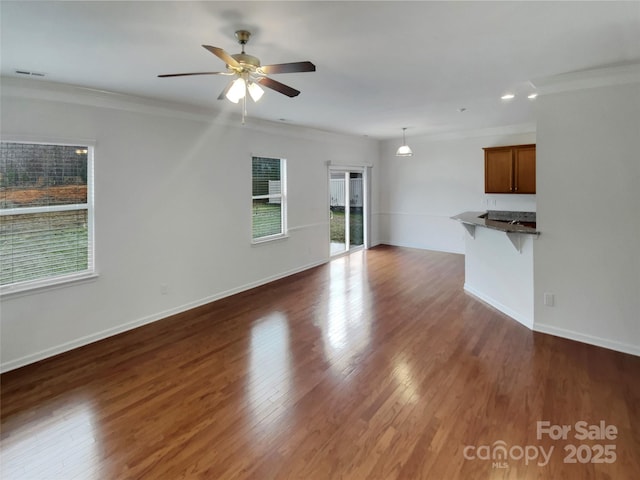 unfurnished living room featuring ornamental molding, ceiling fan, and dark hardwood / wood-style flooring