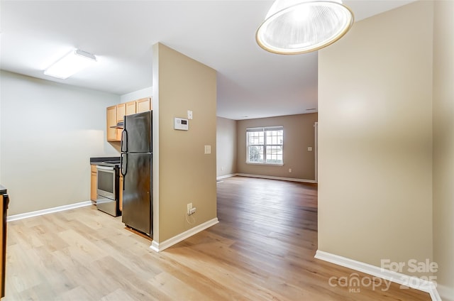 kitchen featuring black fridge, light hardwood / wood-style flooring, stainless steel range with electric cooktop, and light brown cabinets