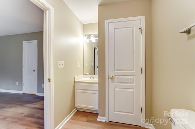 bathroom with hardwood / wood-style flooring, vanity, and toilet