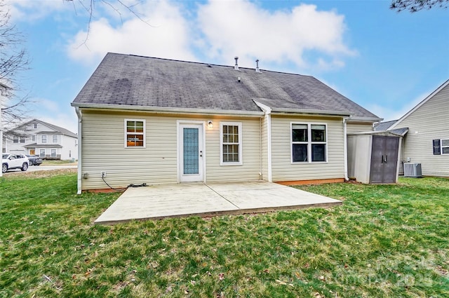 rear view of property with central AC unit, a yard, a patio, and a storage unit