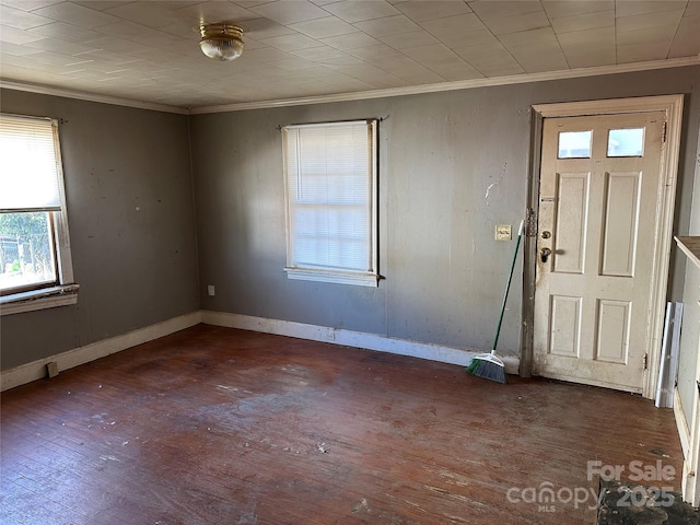 foyer entrance with ornamental molding and dark hardwood / wood-style floors