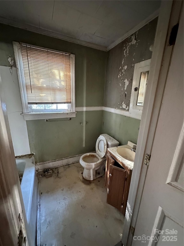 bathroom featuring a washtub, crown molding, concrete flooring, vanity, and toilet