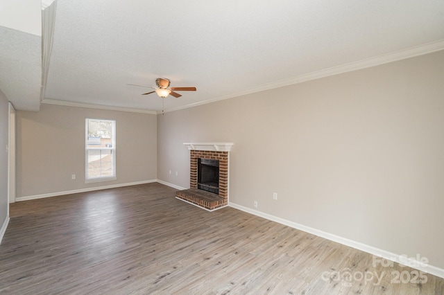 unfurnished living room with crown molding, ceiling fan, light hardwood / wood-style floors, a textured ceiling, and a brick fireplace