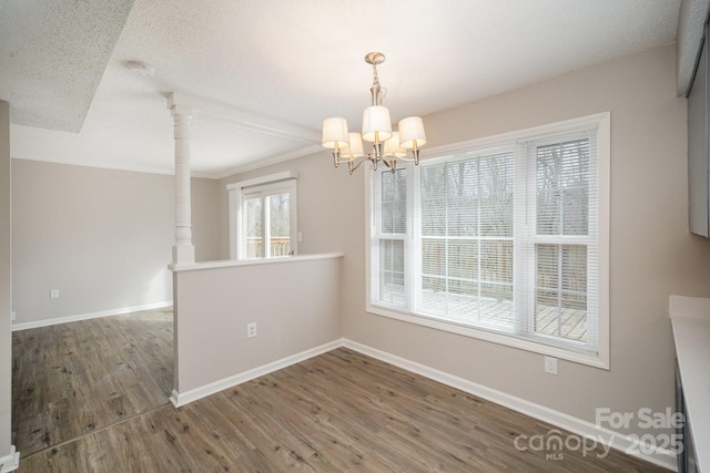 unfurnished dining area featuring dark hardwood / wood-style floors, a chandelier, and a textured ceiling