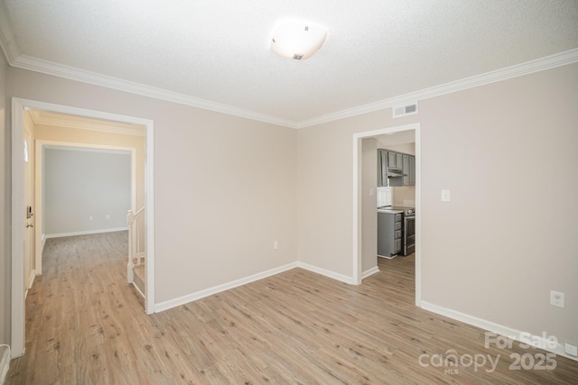 spare room with crown molding, light hardwood / wood-style floors, and a textured ceiling