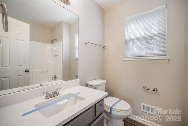 bathroom with a shower, vanity, and toilet