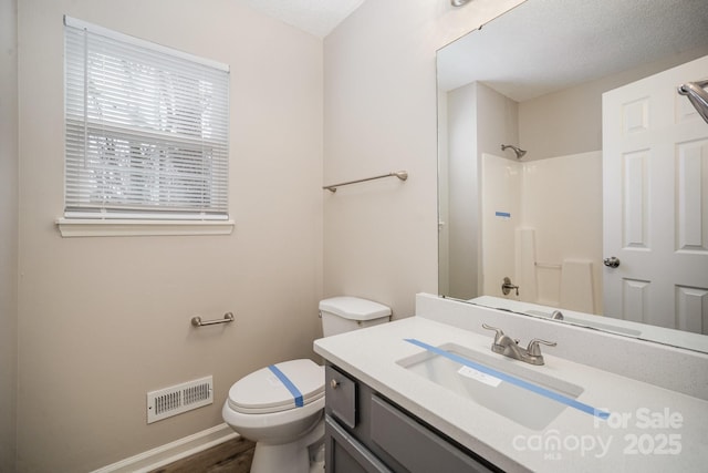 bathroom with hardwood / wood-style floors, vanity, a textured ceiling, toilet, and walk in shower