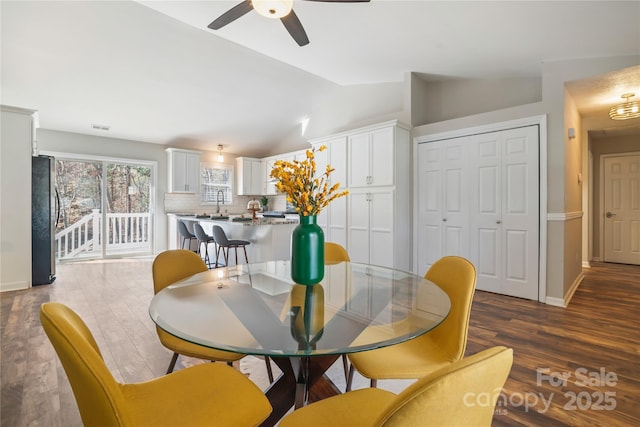 dining area with vaulted ceiling, dark wood-style flooring, visible vents, and baseboards