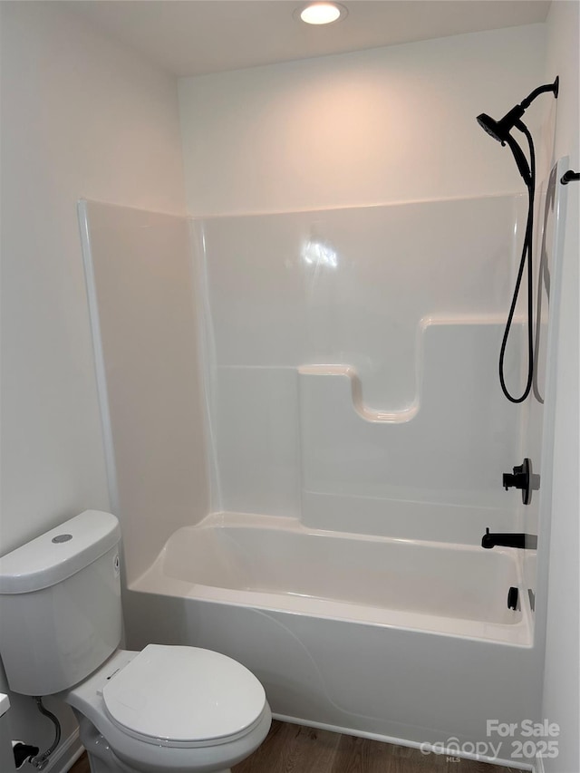 bathroom with shower / tub combination, wood-type flooring, and toilet