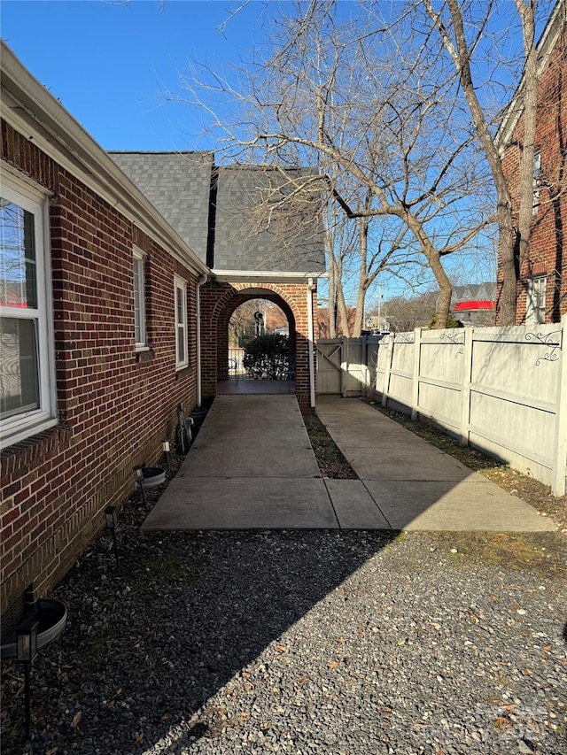 exterior space with a fenced backyard and a gate