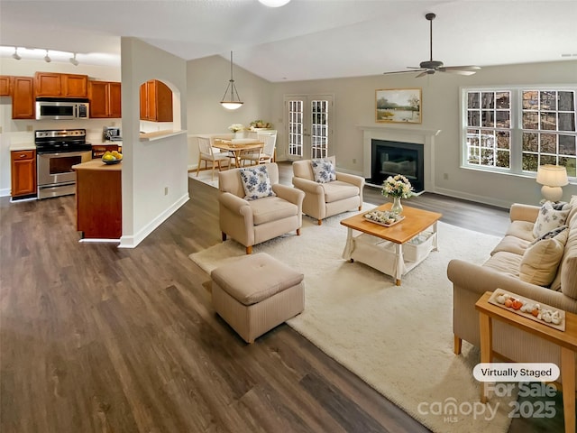 living room featuring lofted ceiling, dark wood-type flooring, and ceiling fan