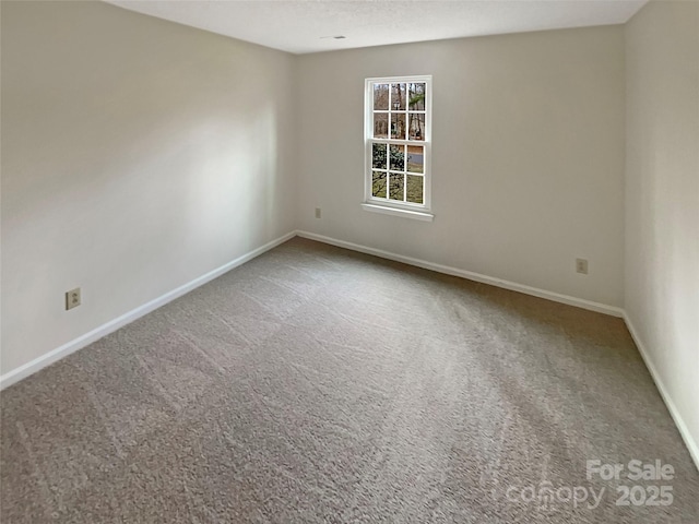 carpeted empty room featuring a textured ceiling